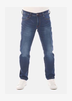 Jeans z denimu w ciemnoniebieskim kolorze o prostym kroju, widoczne szwy i średni stan. W połączeniu z białymi sneakersami.