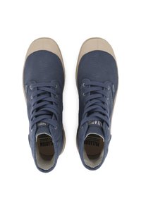 Ζεύγος ναυτικού μπλε καμβά χοντρές αθλητικές κάλτσες με μπεζ καπάκια και σόλες από καουτσούκ, προβαλλόμενες από πάνω σε λευκό φόντο.