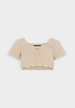Beżowy dziany krótki crop top z falowanymi brzegami i detalem wiązania z przodu, z delikatnym wzorem koronkowym.