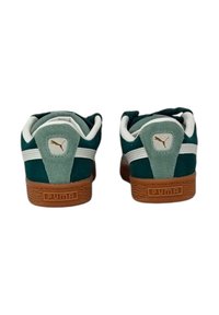 Grüne Wildledersneaker mit weißen Streifen, braunen Gummisohlen und einem goldenen Logo an der Ferse. Weicher Stoff, Low-Top-Design, klassischer Stil.