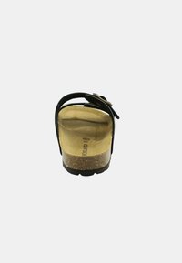 Sandalo nero con suola in sughero, caratterizzato da una sola fascia e hardware decorativo. Parte superiore in pelle liscia con forma ampia e arrotondata.