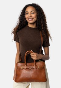 Borsa a mano in pelle marrone con manici doppi e tracolla; presenta dettagli a scaglie e accessori in metallo. Forma rettangolare strutturata.