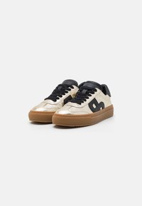 Metallic gold sneakers with black accents, featuring a rounded shape, rubber sole, and textured surface. Lace-up design with padded collar.