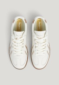 Sneakers bianchi in pelle texturizzata, con dettagli metallici dorati e suola in gomma marrone. Design con lacci, strisce laterali e dettaglio del logo.