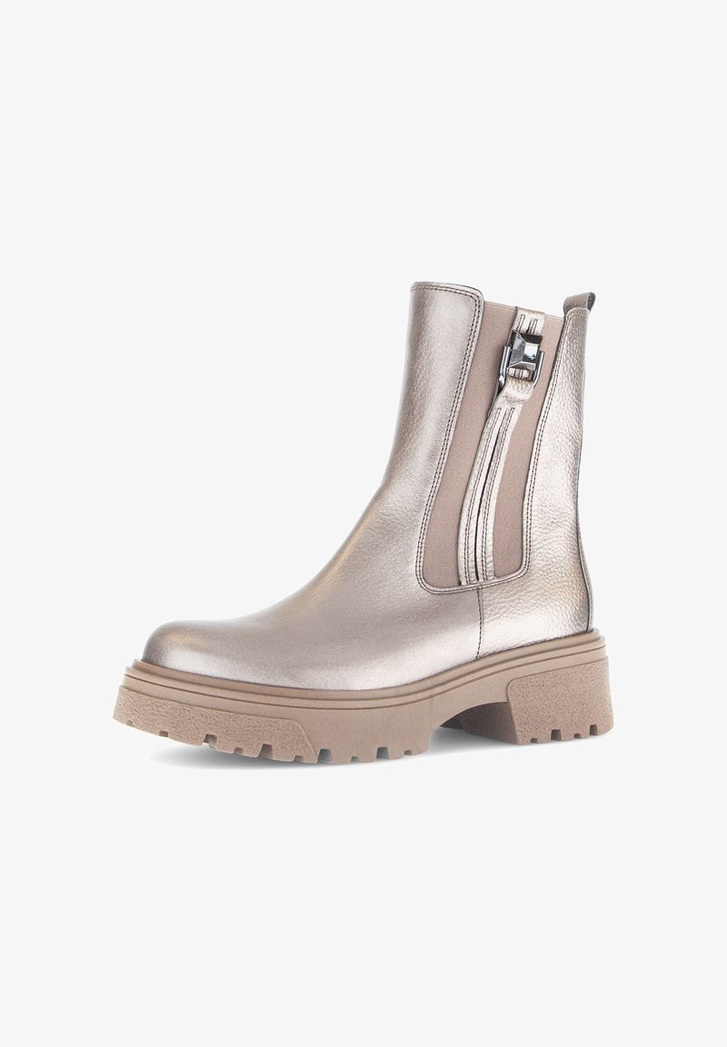 Metallic silver ankle boot with side zipper, tan elastic accents, chunky beige sole, textured finish, and smooth upper material.