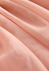Tessuto rosa con una trama a rete, caratterizzato da pieghe morbide e lisce e un'aspetto leggero.