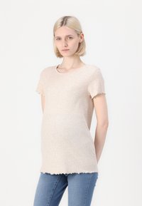 Beige ribbed knit top with short sleeves, round neckline, and frayed hem. Paired with light blue fitted jeans.