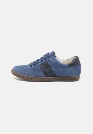 Blue suede sneaker with dark blue accents, round toe, flat rubber sole, and textured detailing. Laces and branding visible on the side.