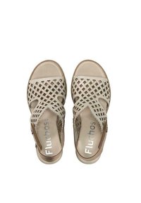 Sandales au design tissé en beige clair avec une semelle lisse, dotées d'un bout ouvert et d'une fermeture éclair au talon pour un enfilage facile. Vue de face.