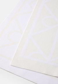 Tapete têxtil em branco suave, com um padrão geométrico subtil em um tom ligeiramente mais claro. Textura suave com um acabamento em tecido.
