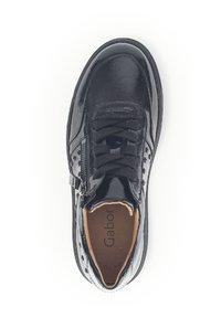 Zwarte leren sneaker met een glanzende afwerking, voorzien van veters, een zijrits en geperforeerde details op het bovenste deel. Interieur is tan.