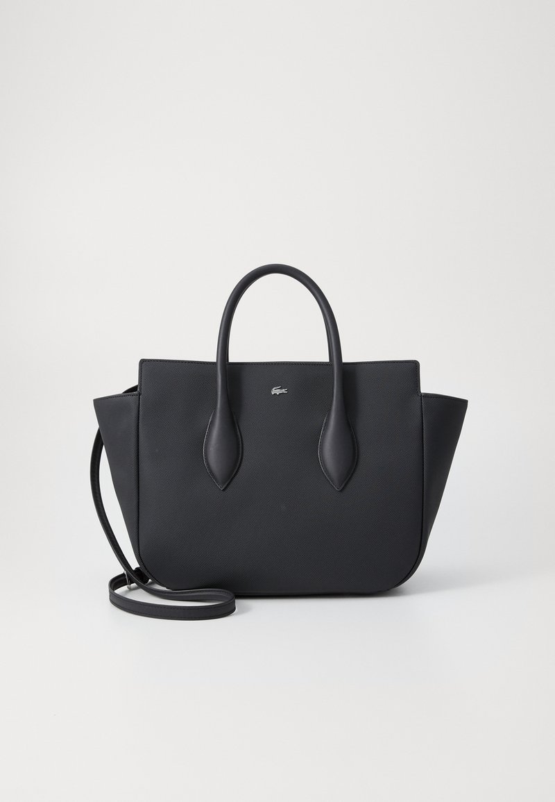 Sac fourre-tout noir en matériau texturé, doté de poignées doubles et d'une bandoulière amovible. Accent logo à l'avant.