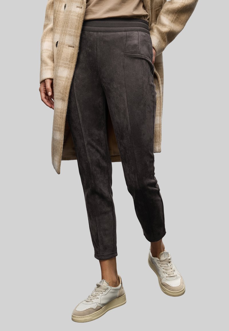 Grå mockajoggingbyxor med texturerad elastisk midja, har sidofickor och en avsmalnande passform, ihop med ljusa sneakers.