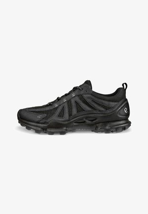 Scarpa sportiva nera con tomaia in mesh e materiale sintetico, chiusura con lacci, suola imbottita e linguetta posteriore.