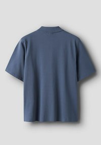 Polo a maniche corte in cotone blu scuro con orlo dritto, colletto a costine e design essenziale. Tessuto liscio, senza motivi o decorazioni visibili.
