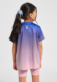 Lila till rosa gradient atletisk skjorta i ett mjukt material, med rund halsringning och tre vita chevroner på baksidan.