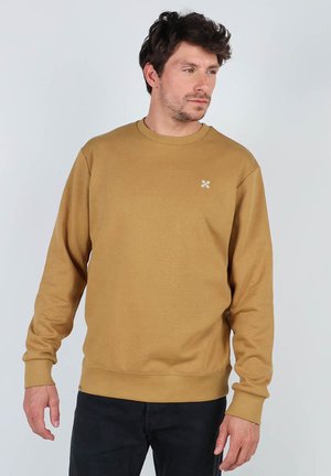 Sweat-shirt marron à manches longues, col rond, avec des poignets et un ourlet côtelés, présentant un petit logo brodé sur la poitrine et une texture douce.