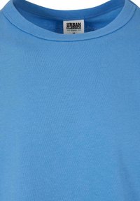 T-shirt en coton bleu clair à col rond avec une étiquette de la marque Urban Classics, taille medium au niveau du col.