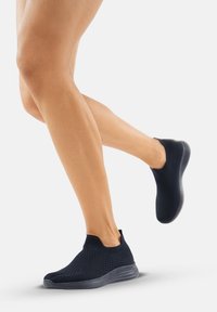 Scarpe sportive slip-on di un blu navy scuro con una parte superiore in maglia tessuta traspirante e suola flessibile, progettate per comfort e facilità di movimento.