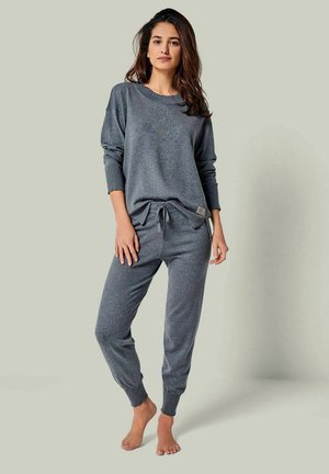 Grau Freizeitkleidung-Set besteht aus einem locker sitzenden Langarmoberteil und Jogginghosen. Weicher Stoff, gerippte Bündchen und eine verstellbare Kordelzugtaille.