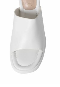 Hvide open-toe hæle sandaler lavet af glat læder. Har en bred overdel og et minimalisitiskt design med en flad sål.