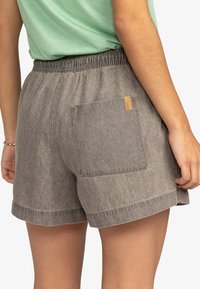 Šedé kraťasy vyrobené z materiálu podobného džínsům. Mají elastický pas, boční kapsy a zadní kapsu s štítkem. Jednoduché ohrnuté okraje.