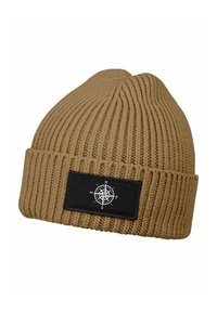Tan knitted beanie with a ribbed texture, featuring a black rectangular patch displaying a white compass design.