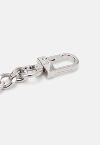 Silver metal chain link with a detachable clasp. The clasp features a locking mechanism and engraved brand logo detail. Smooth, polished surface.