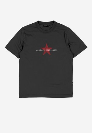 Μαύρο κοντομάνικο μπλουζάκι με κόκκινο αστέρι και λευκό κείμενο "against perfection" στο κέντρο μπροστά.