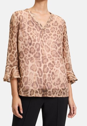 Bluse i leopardmønster i blødt, transparent stof. Har V-udskæring og trekvartlange klokkeærmer. Beige og brune nuancer med subtil glans.