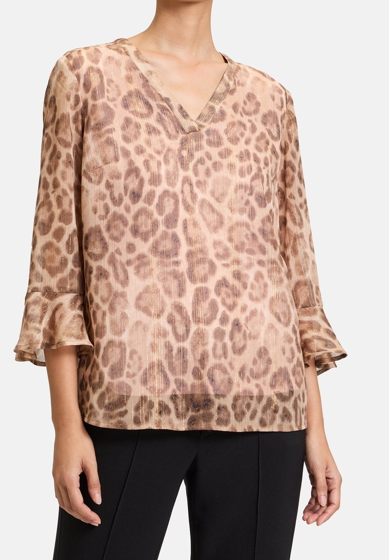 Blus med leopardmönster i mjuk, genomskinlig tyg. Har en V-ringning och trekvartslånga volangärmar. Beige och bruna nyanser med subtil glans.