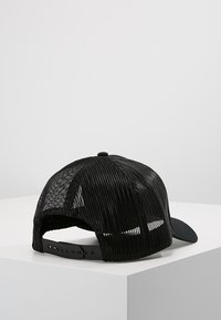 Fekete sapka, szilárd elülső panellel és hálós hátsó résszel. Állítható pánt a méretállításhoz, ívelt csúccsal és diszkrét, dombornyomott logóval.