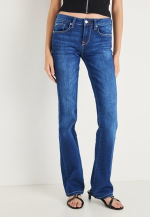 Vaqueros acampanados de mezclilla azul con cintura de talle medio, diseño de cinco bolsillos y costuras en contraste. Textura suave con un leve desgaste en los muslos.