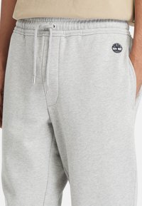 Grå sweatpants lavet af blød bomuldsblanding, med elastisk taljebånd og snøre, sidelommer og et lille broderet logo på låret.