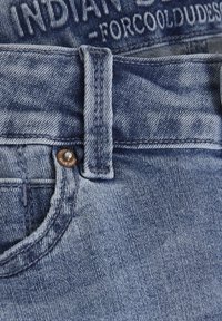 Blå denimjeans med blekt mönster, utrustade med en knappstängning och bälteshällor, som visar en avslappnad design.