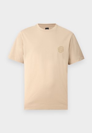 T-shirt beige a maniche corte con scollo rotondo e logo in rilievo sottile sul petto sinistro, mostrata su uno sfondo chiaro.