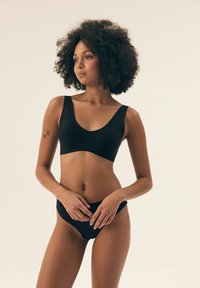 Czarny zestaw bielizny składający się z biustonosza z szerokimi ramiączkami i dekoltem w kształcie litery V, połączony z niskim bikini, gładki materiał i minimalistyczny design.