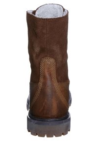 Bota de tobillo de gamuza marrón con una superficie texturizada, forro de piel sintética blanca en la parte superior y una suela de goma gruesa con un diseño de dibujo.