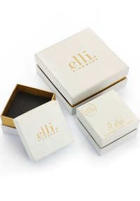 Hvide smykkeskrin med guld accenter, der har "elli diamonds" logoet. Ét skrin er åbent og afslører et sort indre med et kryds-mønster.