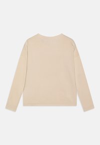 Beige langmouwtop van zachte stof, met een relaxte pasvorm en ronde halslijn, met minimale stikseldetails op de zoom en mouwen.