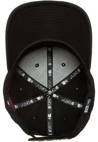 Mustapalli baseball-lippis tasaisella brimillä, jossa on harmaa vuori sisällä, mustat ompeleet ja säädettävä hihna, jossa näkyvät brändilaput.