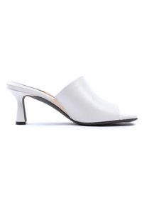Muli bianchi in pelle con punta aperta e tacco basso curvato. Texture liscia e design minimalista, con stile slip-on.