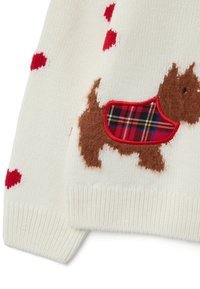 Weißer Strickpullover mit roten Herzmustern. Ein brauner Hund mit einem karierten Umhang, strukturierte Details am Hund. Gerippter Saum.