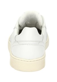 Sneaker in pelle bianca con colletto imbottito, suola texturizzata e suola in gomma crema. Design semplice senza marchi o accenti visibili.
