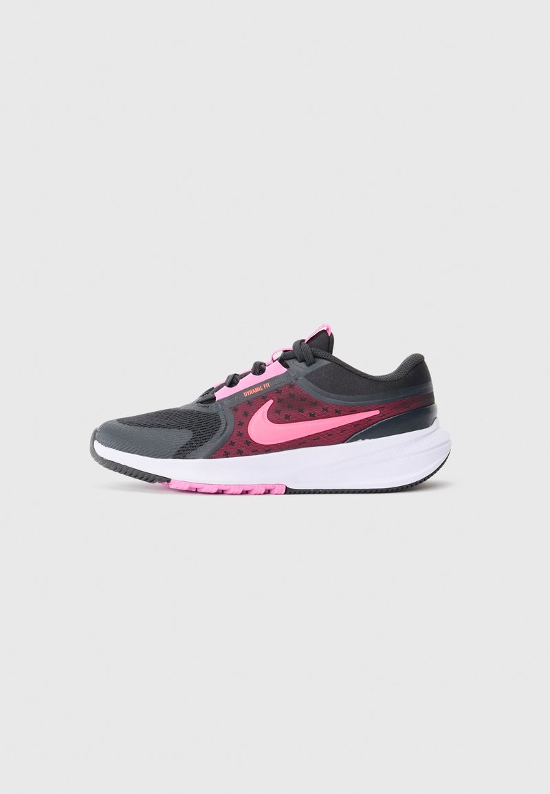 Chaussure de course Nike noire et rose avec une tige en mesh, semelle blanche et étiquette "Dynamic Fit", présentée en profil latéral sur un fond gris.