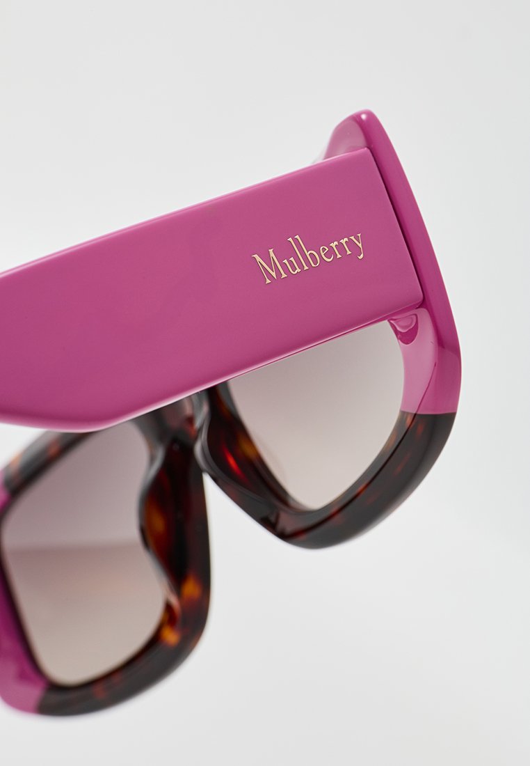 Lila Sonnenbrille mit glänzender Oberfläche, ausgestattet mit einem Schildpattmuster an den Bügeln und goldfarbener "Mulberry"-Markierung an der Schläfe.