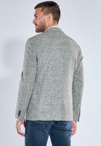 Grauer Tweed-Blazer mit texturiertem Muster, Ein-Knopf-Verschluss und Revers mit Kerbkragen. Er verfügt über kontrastierende Knopfakzente und eine schlanke Passform.