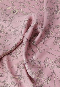 Floral-patterned pink fabric with a soft, smooth texture, featuring intricate lines and botanical designs in cream and darker outlines.