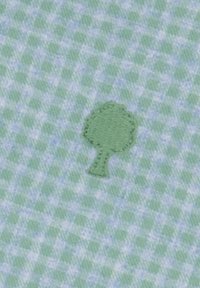Groen geruite stof met een klein geborduurd boompje in een donkerder groen, met een zachte textuur en een subtiele glans.
