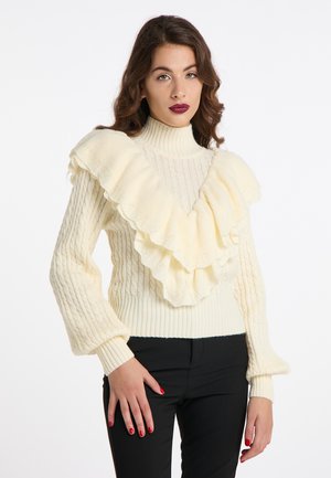 Maglione lavorato a maglia crema con colletto alto, caratterizzato da un grande design a volants nella parte anteriore, polsini a coste e motivi tessuti sul corpo.